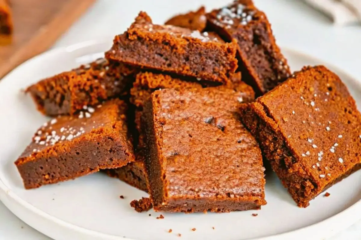 Thick and chewy 2 ingredient fudgy brownies stacked on a white plate