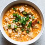 Buffalo chicken cottage cheese bowl with white beans, scallions, and diced grilled chicken in a spicy sauce