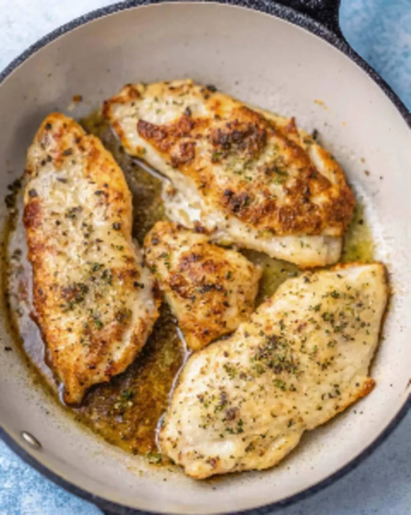 Lemon chicken breast cooked in garlic lemon broth with lemon wedges
